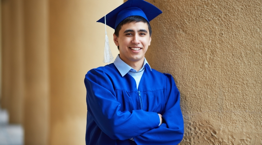 Boy in graduation gown standing